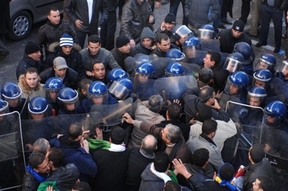 Demonstrators, foreground, asking for political change in their country, face riot policemen, background, in Algiers on Saturday. 